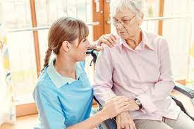 מטפלת משוחחת עם קשישה בבית